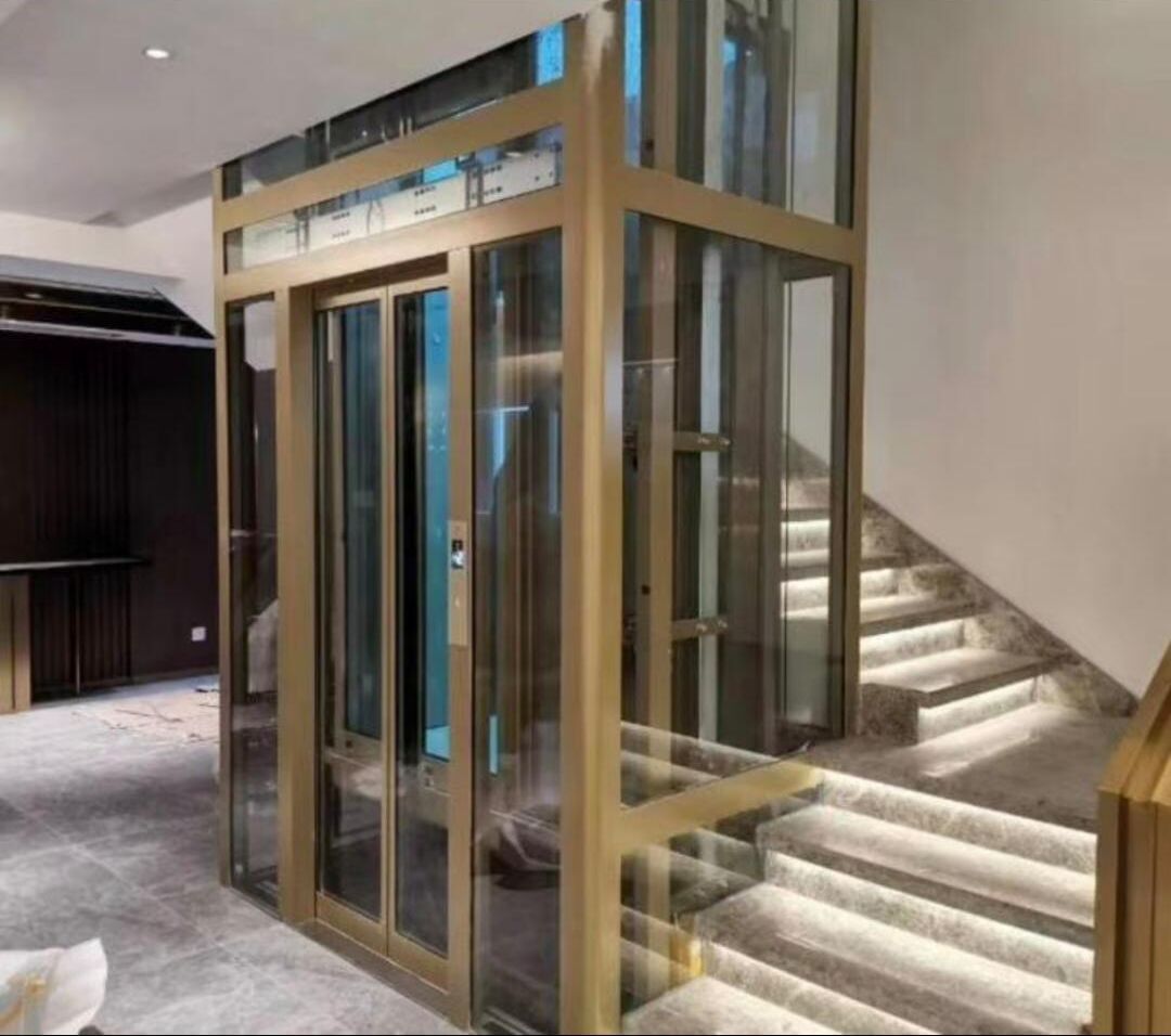 Panoramic elevator with a champagne frame beside a lit staircase