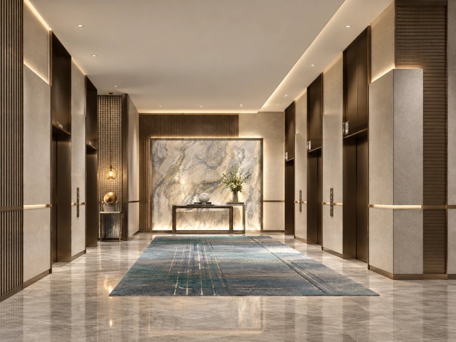 Hotel elevator lobby with a marble feature wall and bronze doors