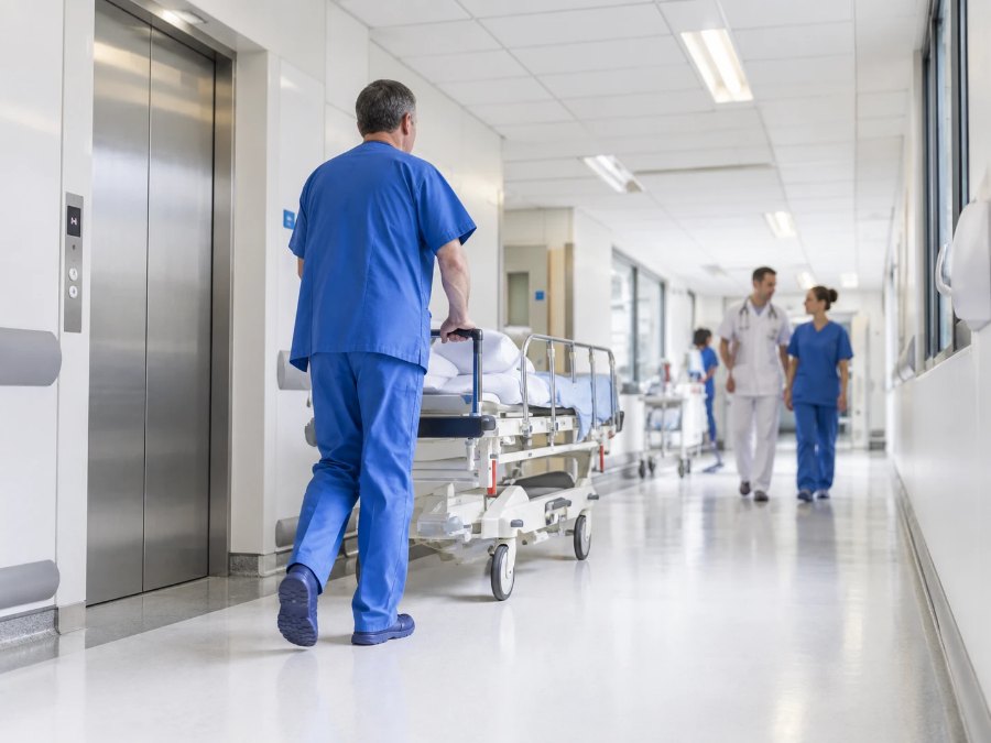 Hospital corridor with a gurney beside the elevator doors