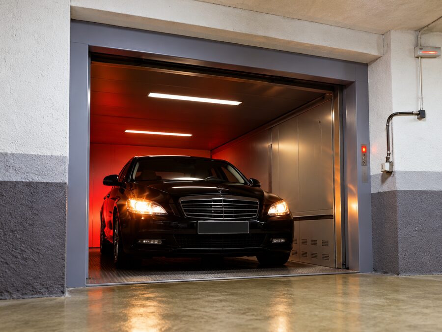 Car driving into a vehicle elevator in a parking garage