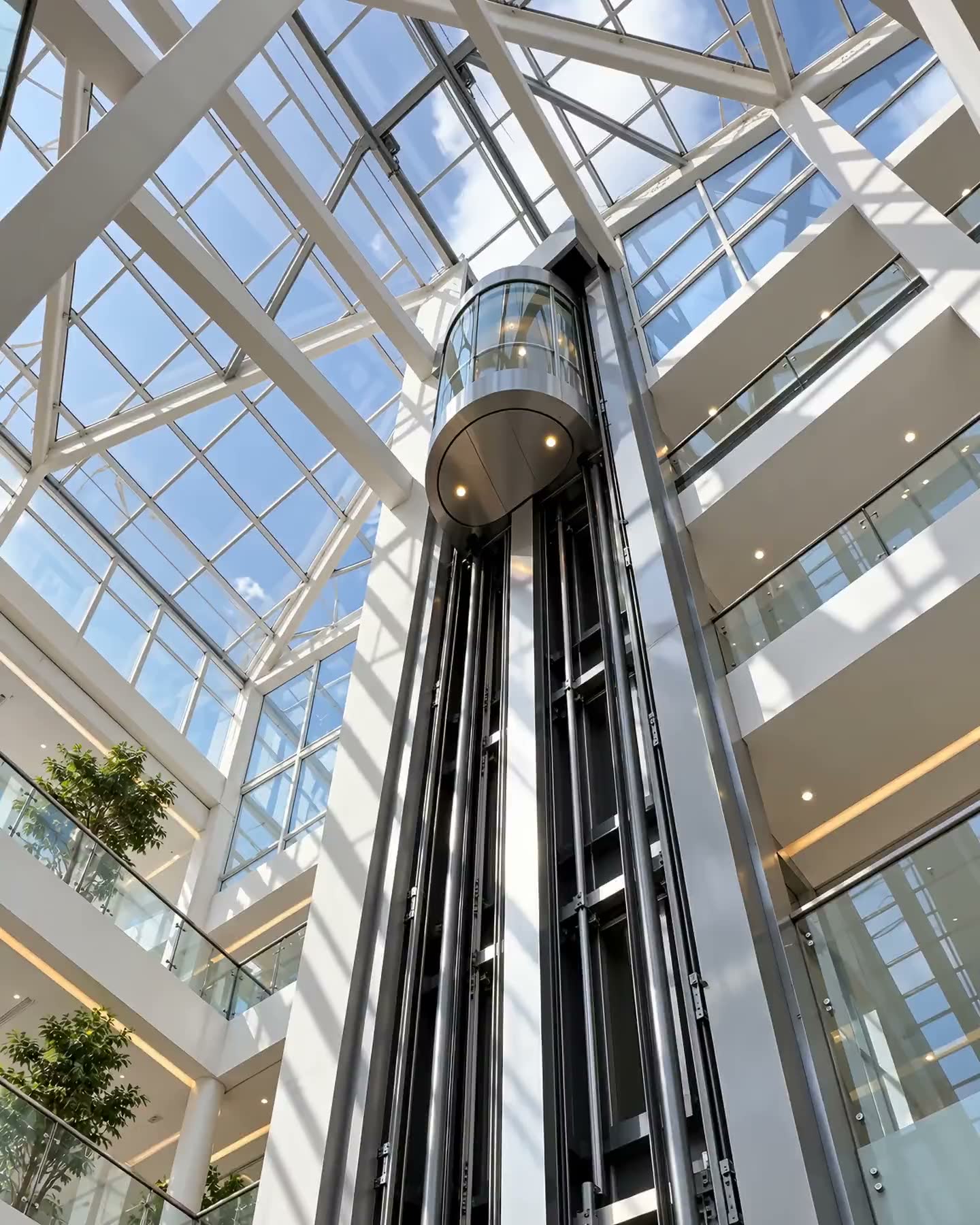 Panoramic elevator descending in a glass atrium